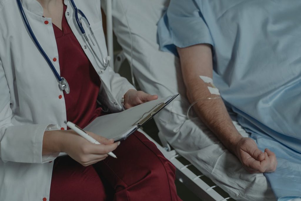 A doctor sitting beside a patient